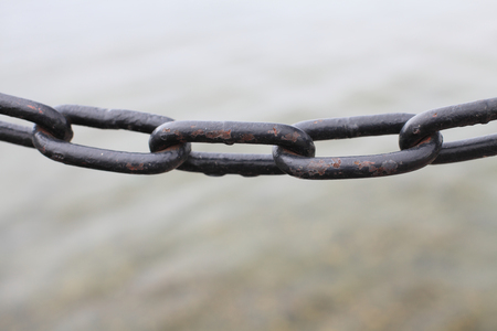 Black chain close-up, which links the large size on a background of water.