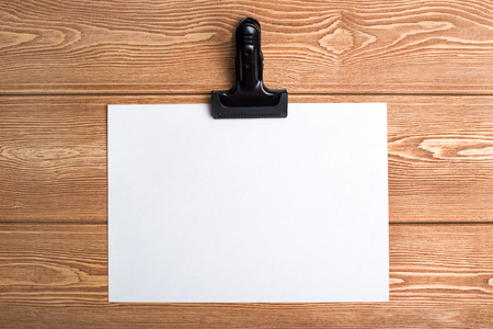 Writing paper with a clip on the wood backgroundの写真素材