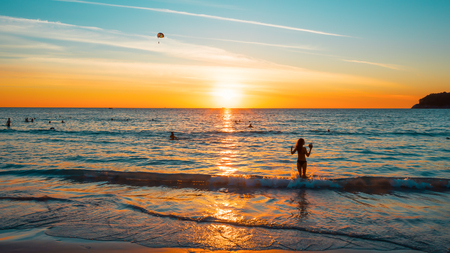 Sunset on a tropical beach. The picture aspect ratio is 16: 9. The face and figure of the girl are changedの写真素材