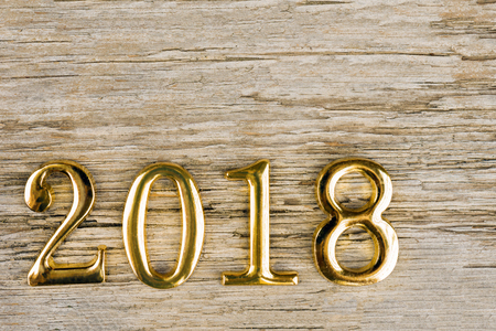 Gold metal figures 2018 on an old wooden background