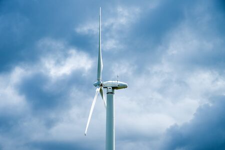 Wind turbine on a cloudy sky backgroundの写真素材