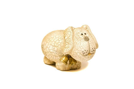 Ceramic figurine of dog with goldish bells is isolated on whiteの写真素材