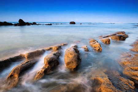 Big waves and sunrise with texture of rock locations Sawarna Beach Banten Indonesia with reef rock...