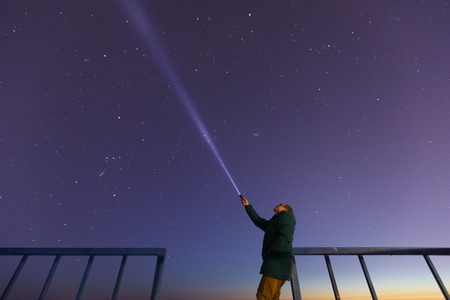 Silhouette of a man with a flashlight, observing beautiful. Astronomy, orientation, clear sky...