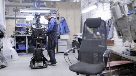 Engineer for his workplace. Creates a modern technical robot. The disassembled case of the robot...