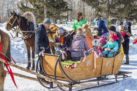 Berdsk, Novosibirsk region, Siberia, Russia - March 13, 2016: Russian holiday Maslenitsa ( farewell to winter, welcoming the spring ). Horse riding children in the city Parkのeditorial素材