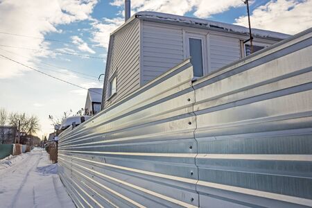 Suburban fence of corrugated galvanized iron. Russia, Siberia, Novosibirsk region, Berdskのeditorial素材