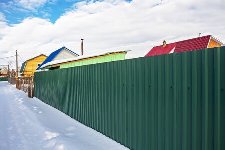 Suburban fence of corrugated iron coated. Russia, Siberia, Novosibirsk Region, Berdskのeditorial素材
