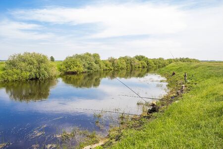 The river Kargat, Novosibirsk oblast, Siberia, Russia - June 12, 2016: a fisherman catches a fish on the river on a floatのeditorial素材