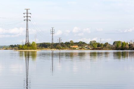 The supports of overhead power lines installed in the river. The river Berd, Berdsk, Novosibirsk oblast, Siberia, Russiaの写真素材