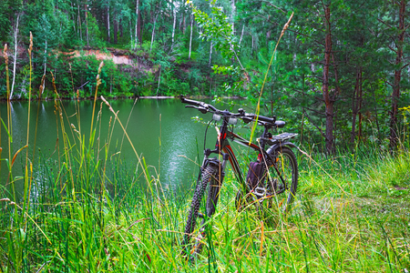 The Separate river (a tributary of the Ob river), in Novosibirsk oblast, Siberia, Russia - July 21, 2017: a mountain bike on the river in the summerのeditorial素材