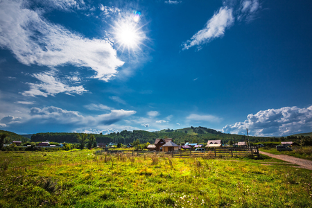 Aya village, Gorny Altai, South Siberia, Russia-August 25, 2018: rural landscape with residential houses on the background of hills