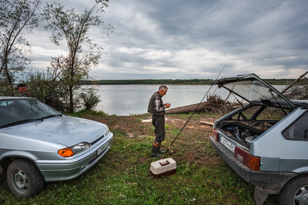 Ob river, Novosibirsk region, Suzun district, Western Siberia, Russia-August 21, 2018: Autotourist prepares gear for fishing on the river Bankのeditorial素材