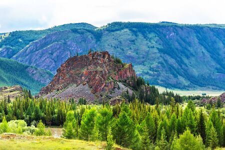 Red mountain surrounded by coniferous forests and the Altai mountains. Altai Republic, South Siberia, Russiaの写真素材