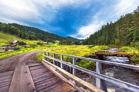 Lower Kuyum village,Chemal district, Altai Republic, South Siberia, Russia - August 14, 2019: wooden road bridge over the Kuyum river near the village of Lower Kuyumのeditorial素材