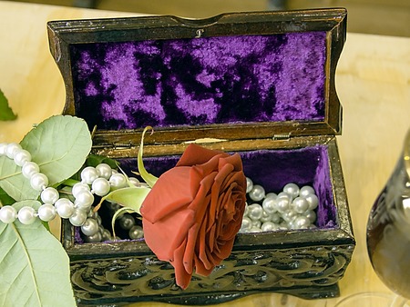 A beautiful red rose and pearl necklace on a jewelry box.の写真素材
