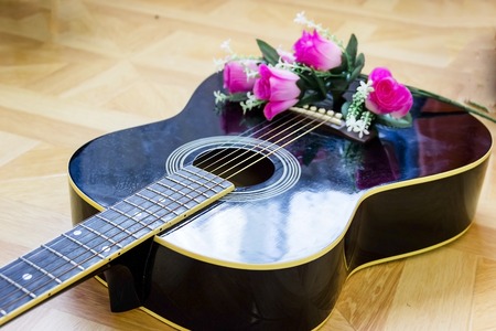Acoustic guitar laying on bed low angle shot from bottom with plectrum on the bodyの写真素材