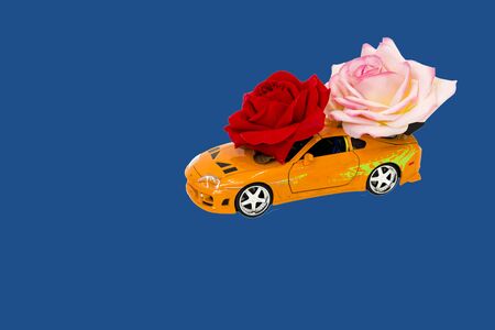 pictured in the photo toy car with roses on blue backgroundの写真素材