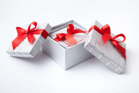 Isolated gift boxes with red satin ribbons on white background