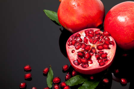 Isolated group pomegranate with leaf and seed on black backgroundの写真素材
