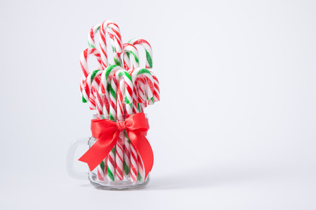 Mint hard candy cane striped in jar Christmas colours and snow man isolated on a white background....