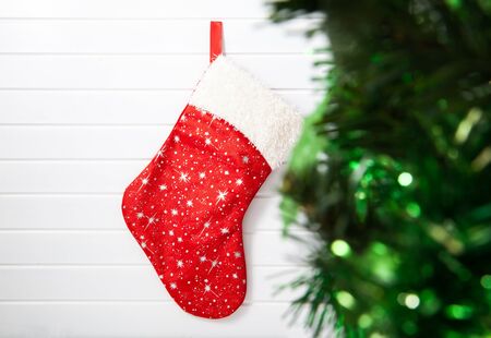 Red Christmas sock hanging on white wood
