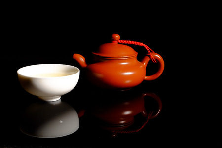 Hot Chinese tea in pot and cup on black backgroundの写真素材