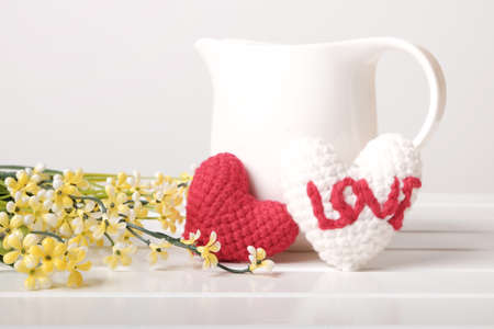 Two hearts shaped, White jug and Yellow flower on white backgroundの写真素材