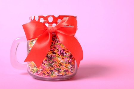 colorful sugar sprinkles in jar on pink background, decoration for ice cream and bakeryの写真素材