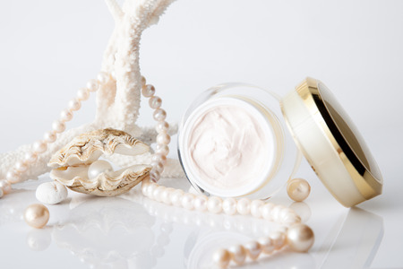 Nameless cosmetic jar and pearl in shell decorated with pearl necklace on white backgroundの写真素材