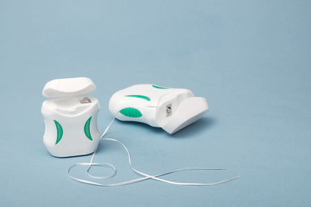 Dental care; Dental floss on light blue background.のeditorial素材