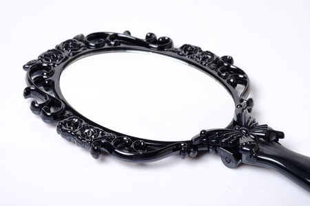 Close up of black vintage hand mirror on white background.のeditorial素材