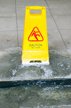 A sign indicating wet floors, frozen to the floorの写真素材