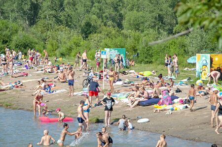 People have a rest near the river, on a city beach. On a hot sunny dayのeditorial素材
