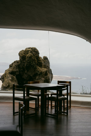 Wooden table and chair in cafe with view on the sea.