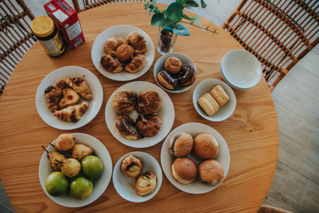 Breakfast with croissants and pastries on a wooden tableの写真素材