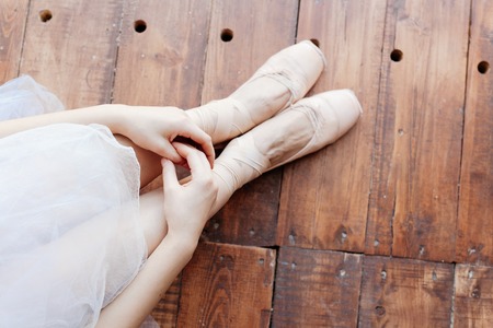 Young ballerina standing on poite at barre in ballet classの写真素材