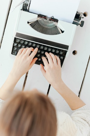 Unidentified woman's hand typing on retro typing machine.の写真素材