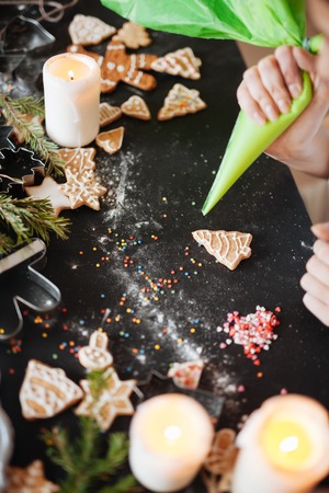 Traditional Xmas frame with spices, speculoos biscuits, star cookies and assorted nuts decorated with dried orange around central copyspace on a rustic wood background for your Christmas messageの写真素材