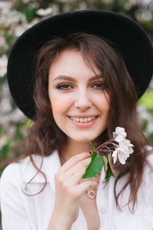Beautiful woman enjoying after relaxing outdoor, having fun, holding plant, happy young lady and spring green natureの写真素材