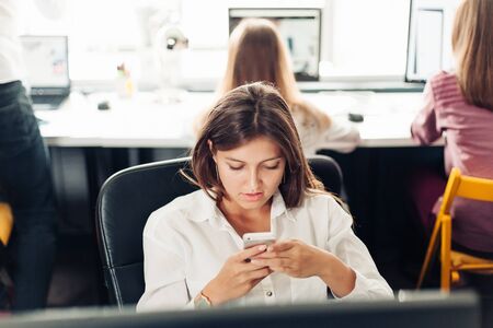 designer woman using phone in the officeの写真素材