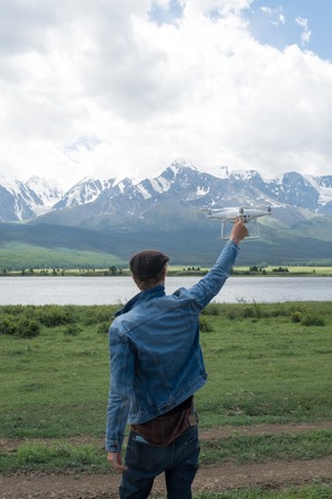 Man controling a drone on mountain background.の写真素材