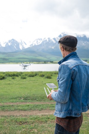 Man controling a drone on mountain background.の写真素材