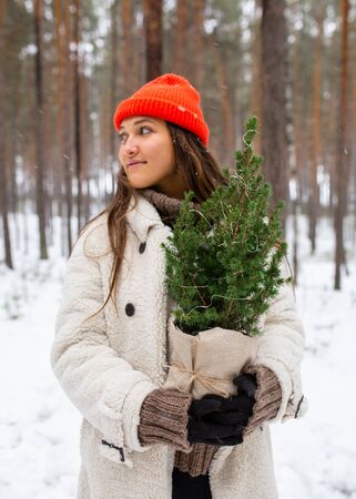 Young woman embracing tree in winter forest.の写真素材