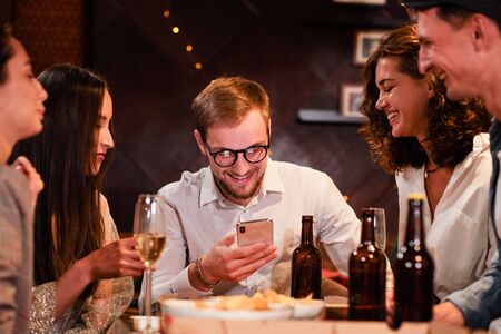 Happy group of friends at the bar having drinks.の写真素材