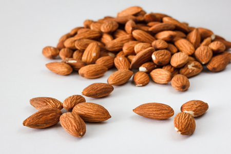 Nuts and honey photoset. A handful of almonds isolated on a white backgroundの写真素材