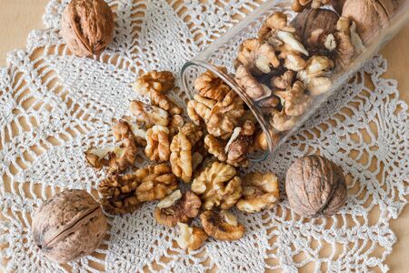 Nuts and honey photoset. Walnut in a glass on a table with lace napkin.の写真素材