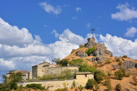 Pennabilli, Castle of Billi. The ruins of the ancient fortress of Billi and the large metal cross located on the top of the Rupe di Pennabilli, one of the most beautiful villages in Italy.の写真素材