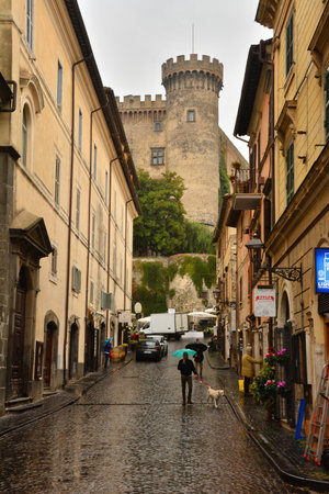 Bracciano, Rome, Italy-Borgo di Bracciano and Castello Orsini-Odescalchi-A street of the town of Bracciano and in the background one of the towers of the imposing castle.のeditorial素材
