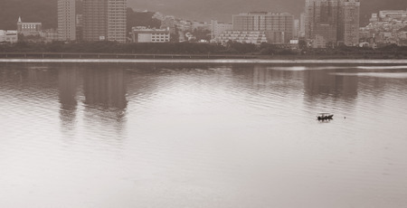Building reflection of the river and a fishing boat